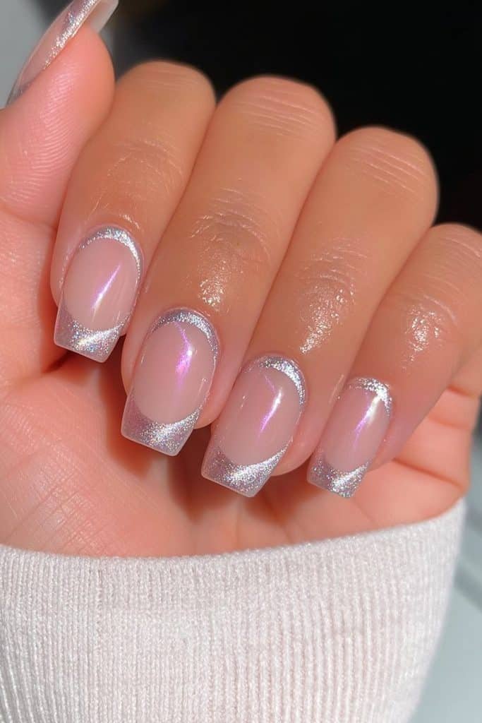Short squoval nails with silver velvet magnetic French tips on milky nude bases.