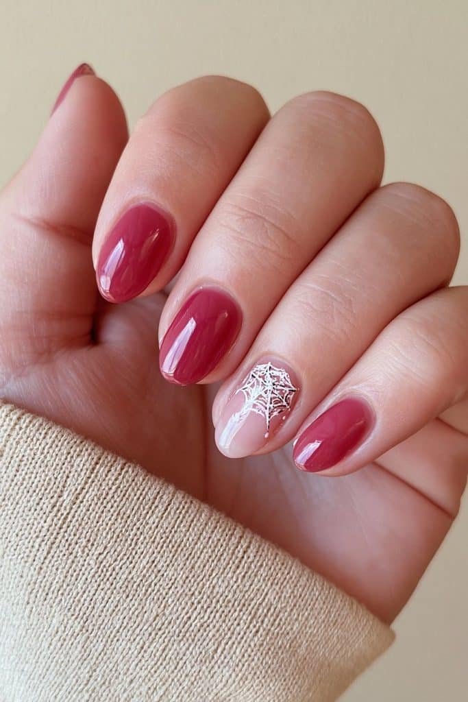 Short nude nails with one delicate spiderweb accent.