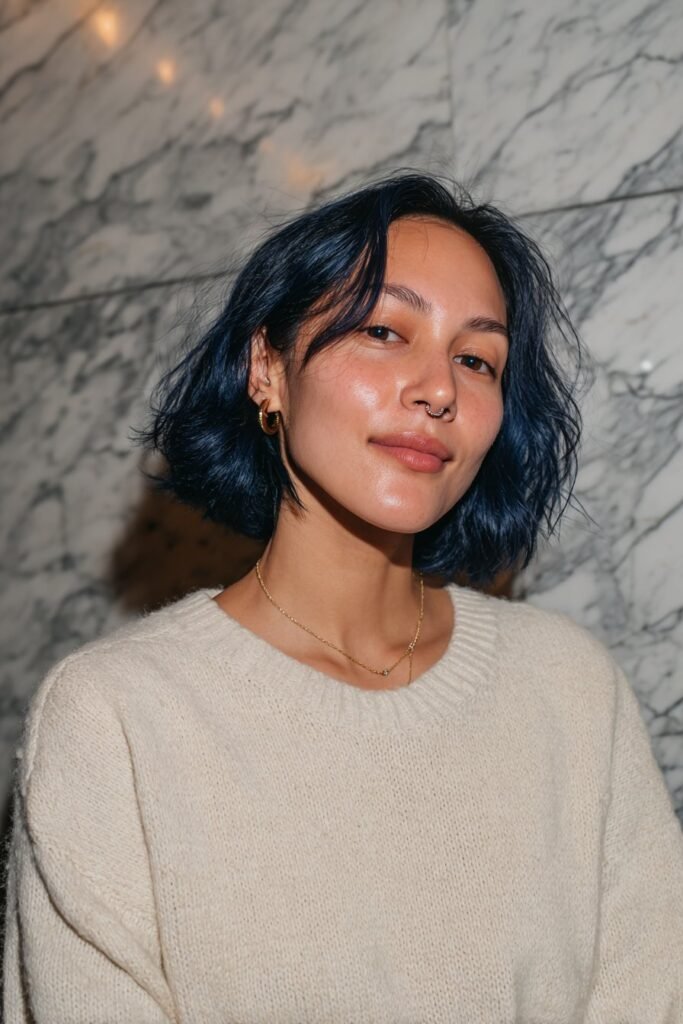 Medium close-up portrait of a woman showcasing a sleek midnight blue bob hairstyle