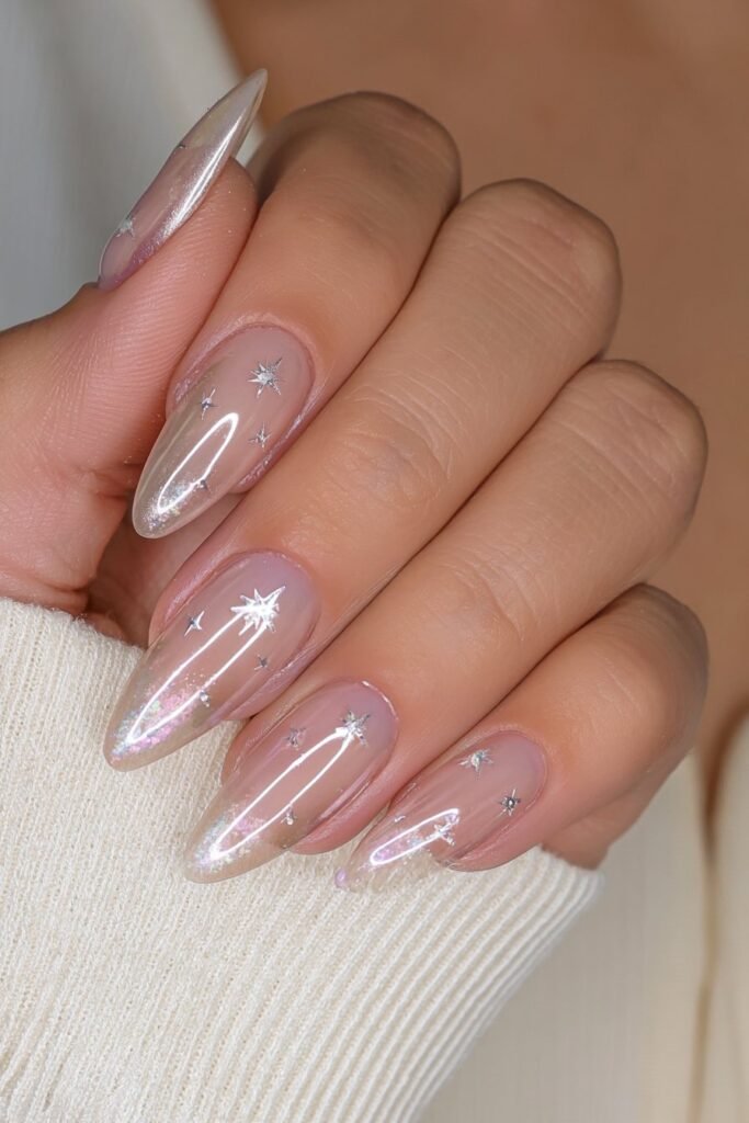 Champagne chrome almond nails decorated with tiny star studs.
