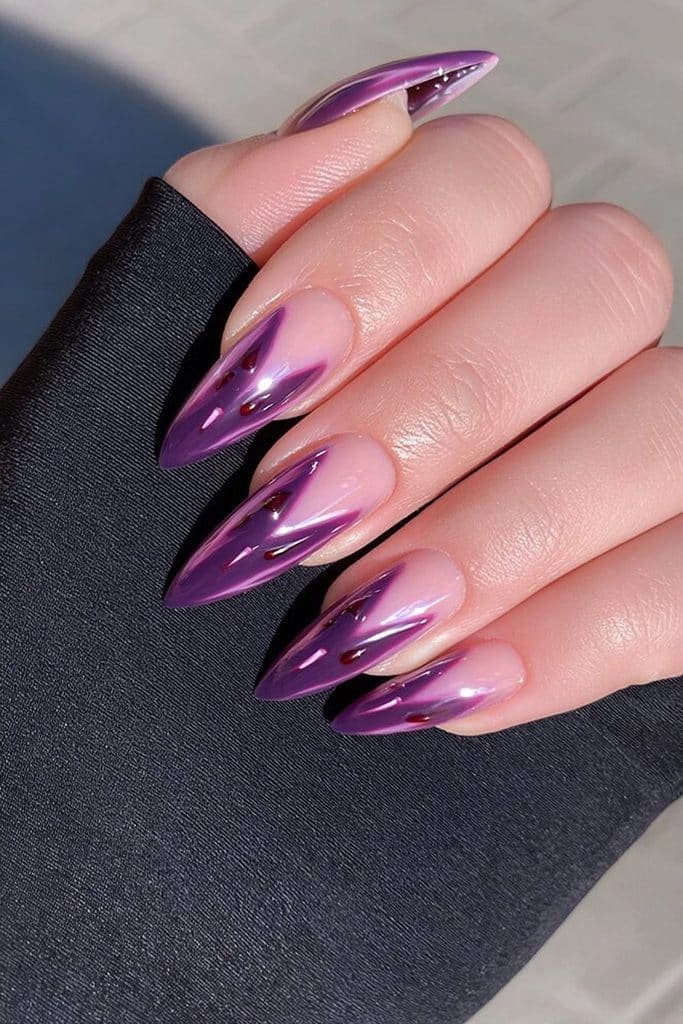 Short vampire-purple stiletto nails with dark red spooky accents.