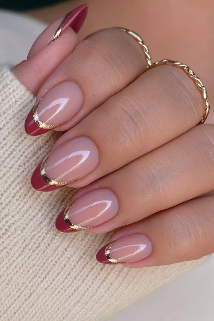 Short almond Thanksgiving nails with terracotta French tips and delicate gold edges.