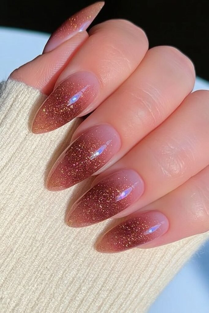 Warm terracotta almond nails with fine golden shimmer.