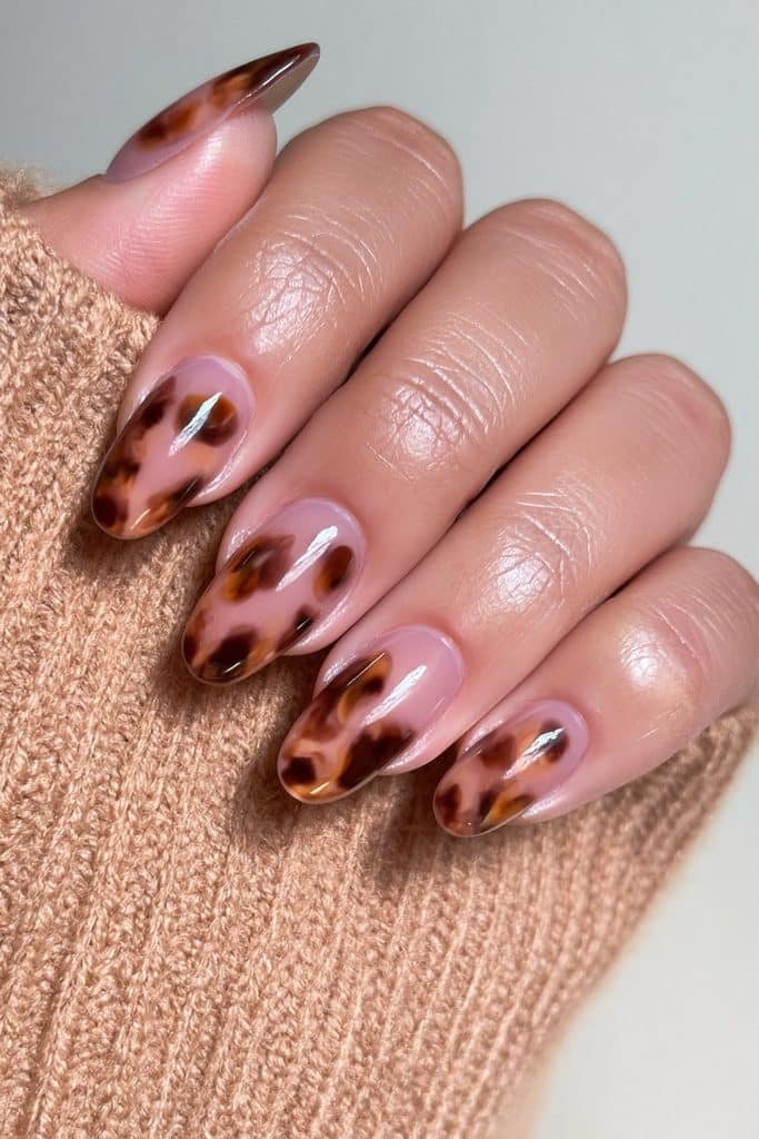Short round nails with chocolate brown tortoiseshell and caramel swirls