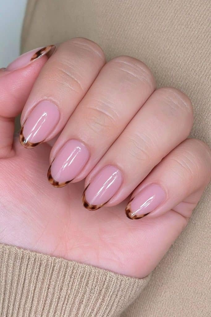 Short round Thanksgiving nails with amber and brown tortoiseshell French tips.
