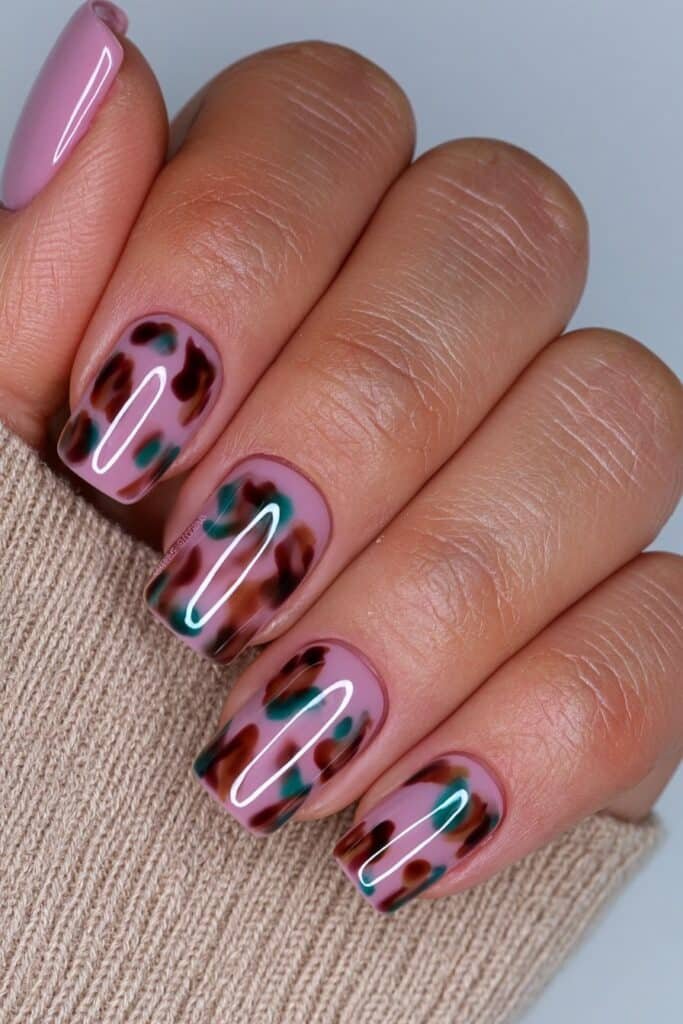 Short tortoiseshell nails in warm amber and brown tones.