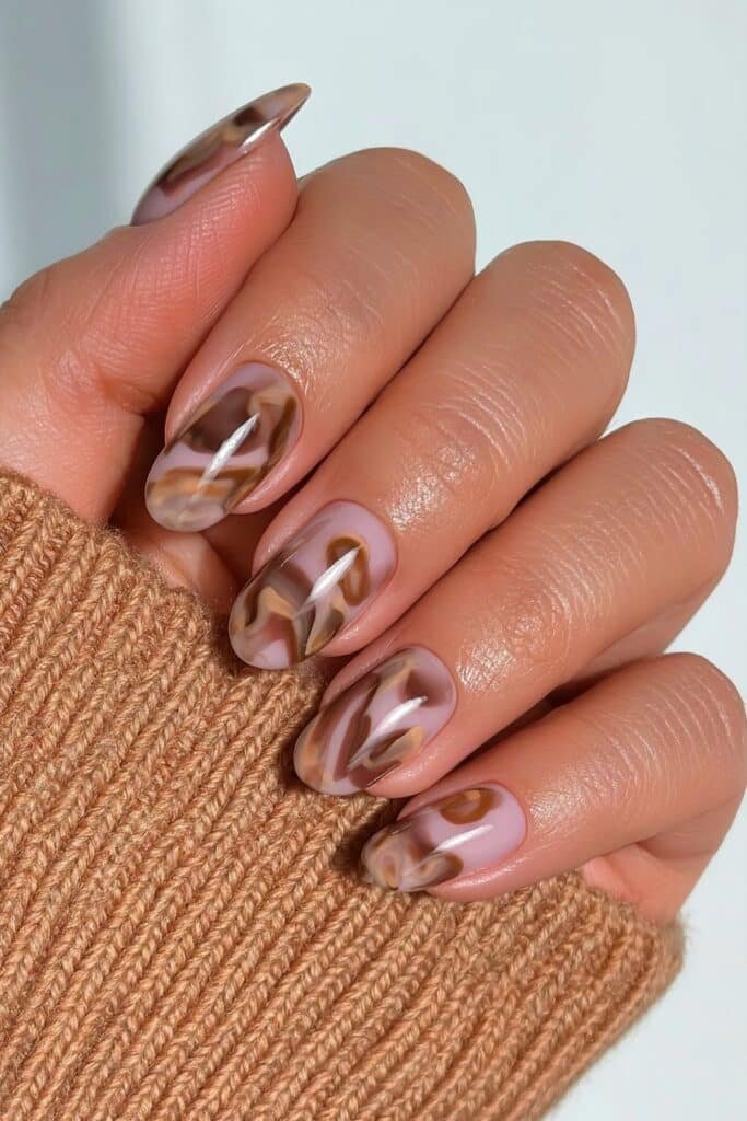 Short oval nails featuring chocolate, caramel, chestnut, and amber tortoiseshell swirls.