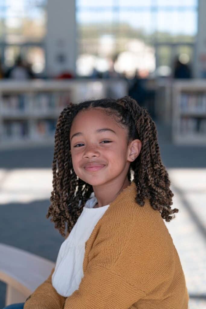 Little Black girl with medium two-strand twists and curled ends