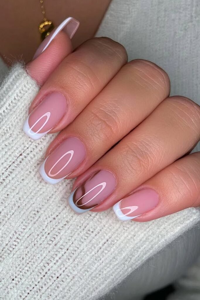 Short blush nails with ultra-thin white French tips.