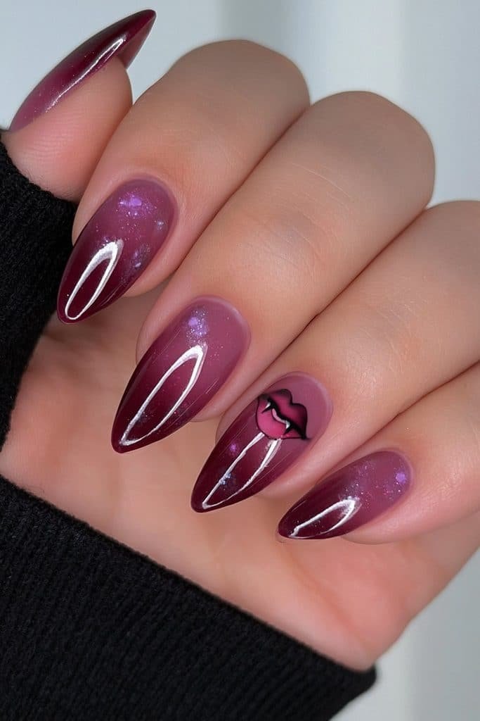 Short burgundy almond nails with a tiny vampire lip accent.