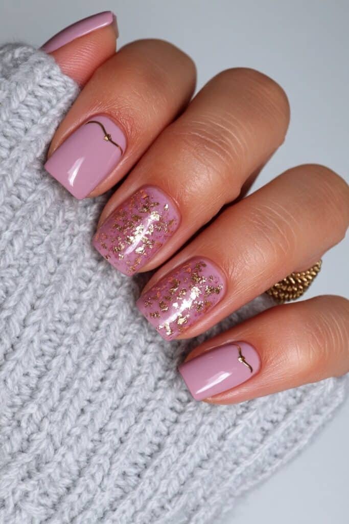 Short taupe nails with delicate gold foil accents.