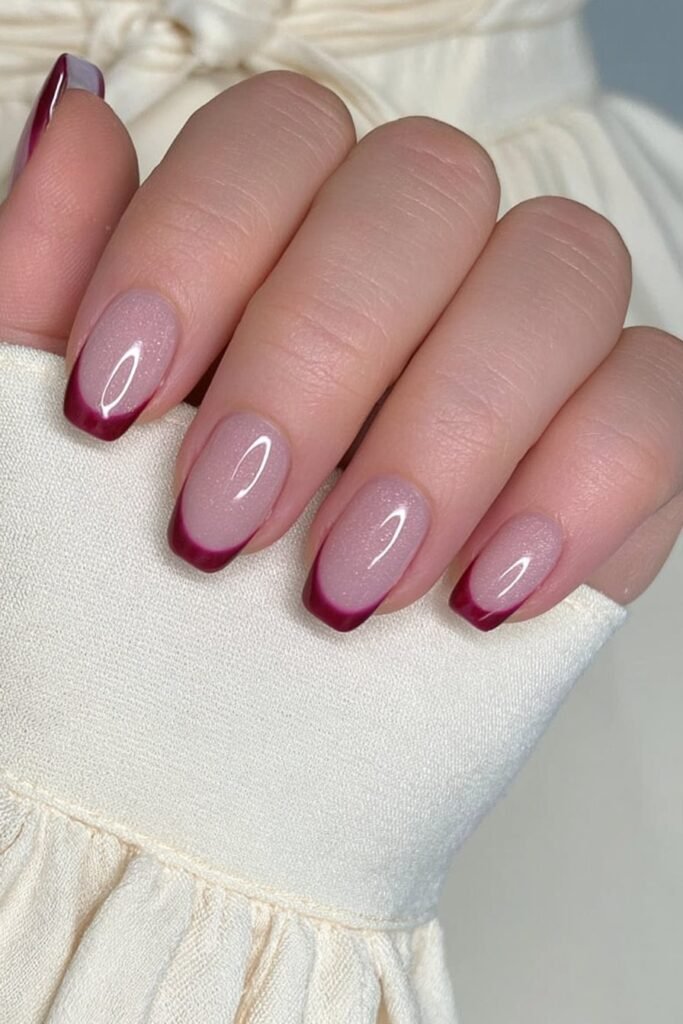 Short nude nails with rich wine red French tips.
