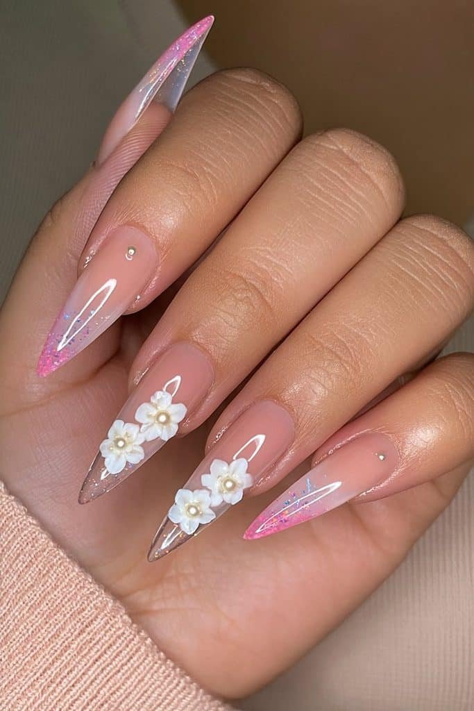 Milky pink stiletto nails with raised white floral accents