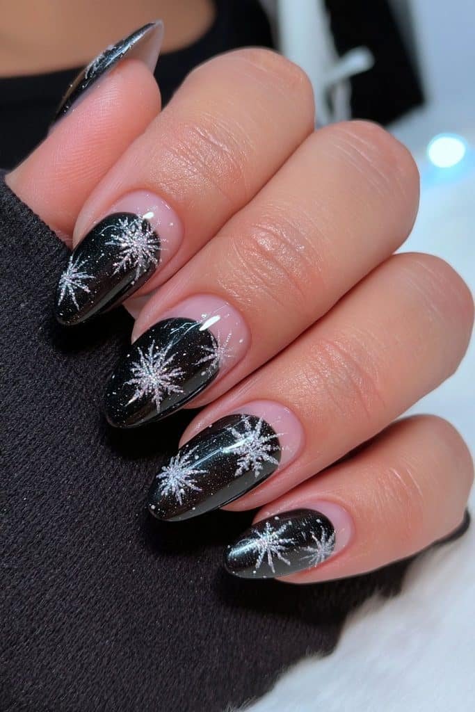 Glossy black nails with intricate white snowflakes