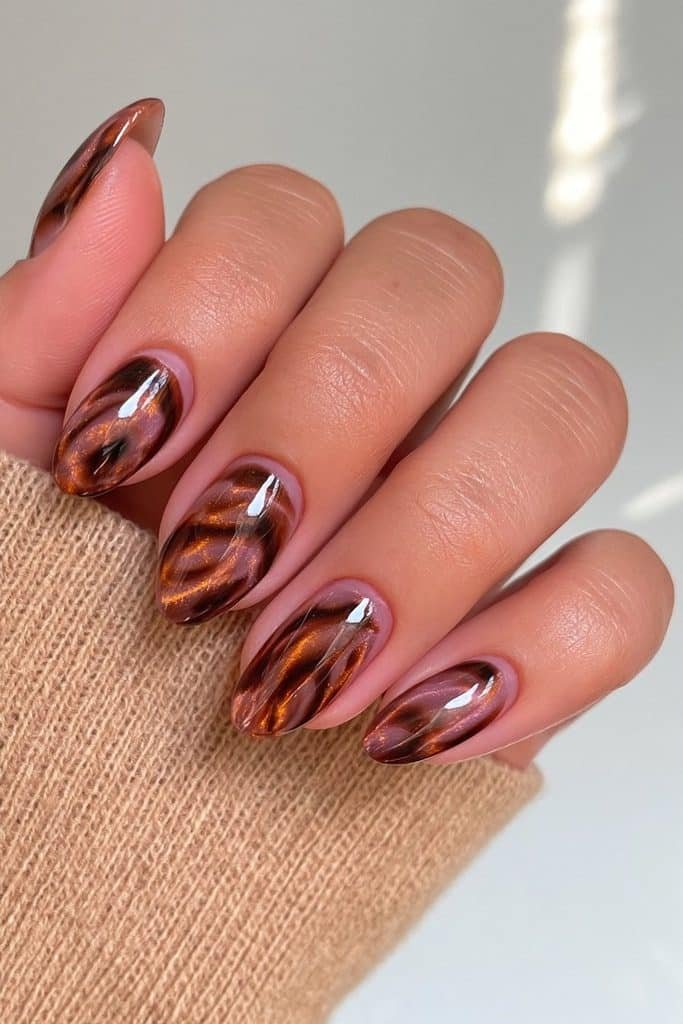 Amber tortoiseshell nails with subtle magnetic cat-eye shimmer