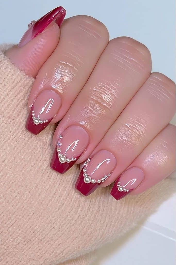 Glossy cranberry tip nails with tiny pearl accents