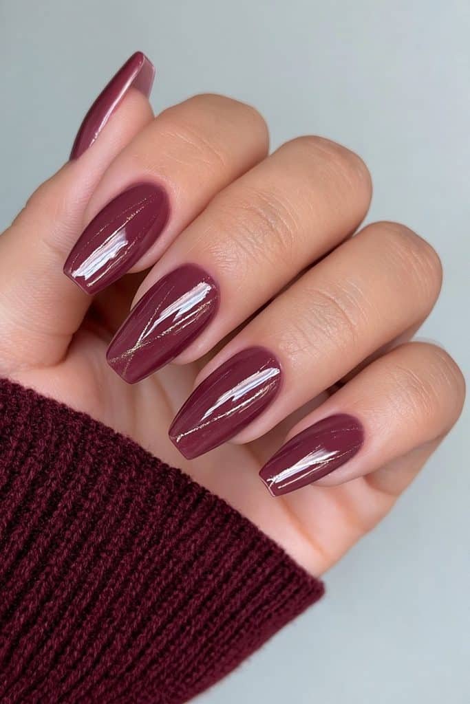 Deep burgundy coffin nails with delicate gold line art