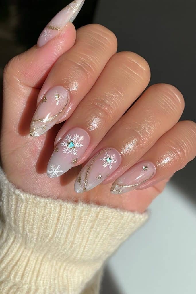 Milky white nails with gold swirls and snowflake accents