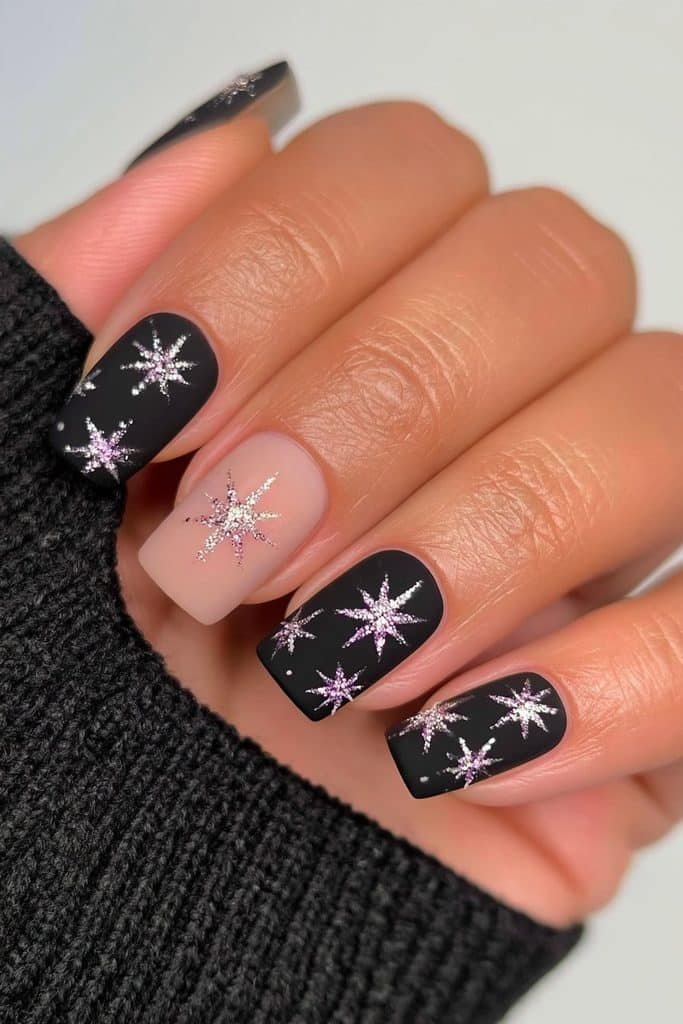 Matte black nails with white snowflake accents