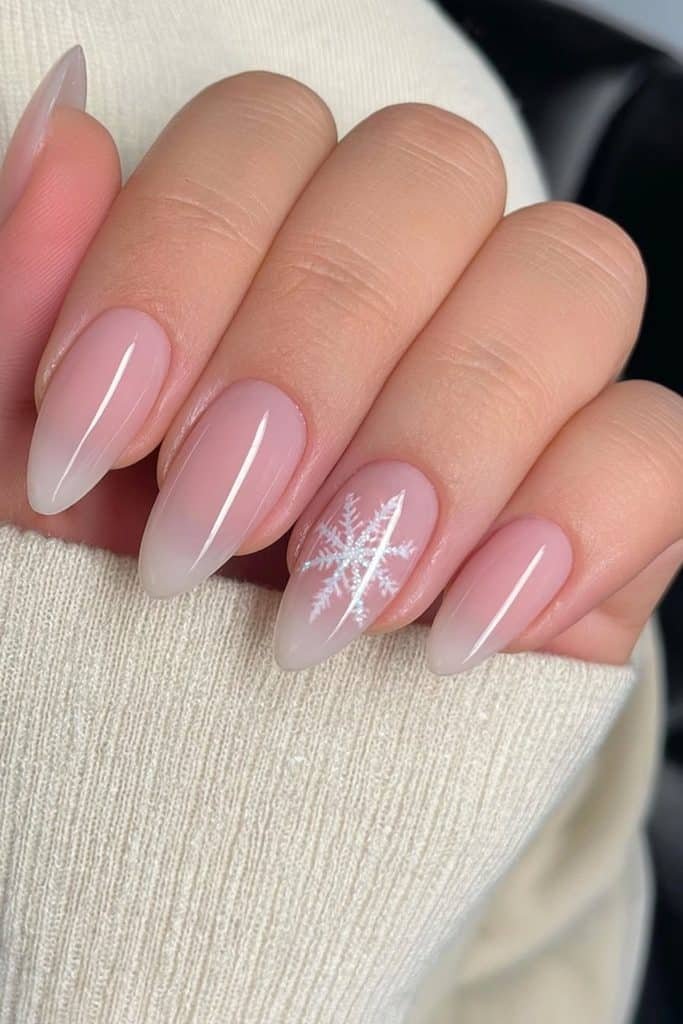 Milky pink nails with a single snowflake accent