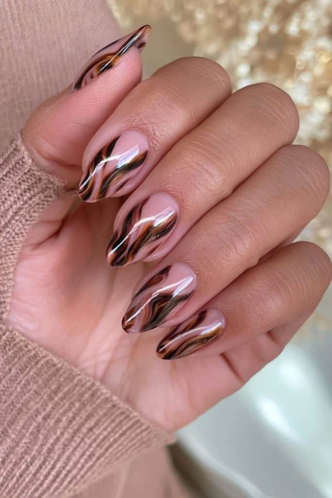 Glossy tortoiseshell swirl nails in amber and espresso tones