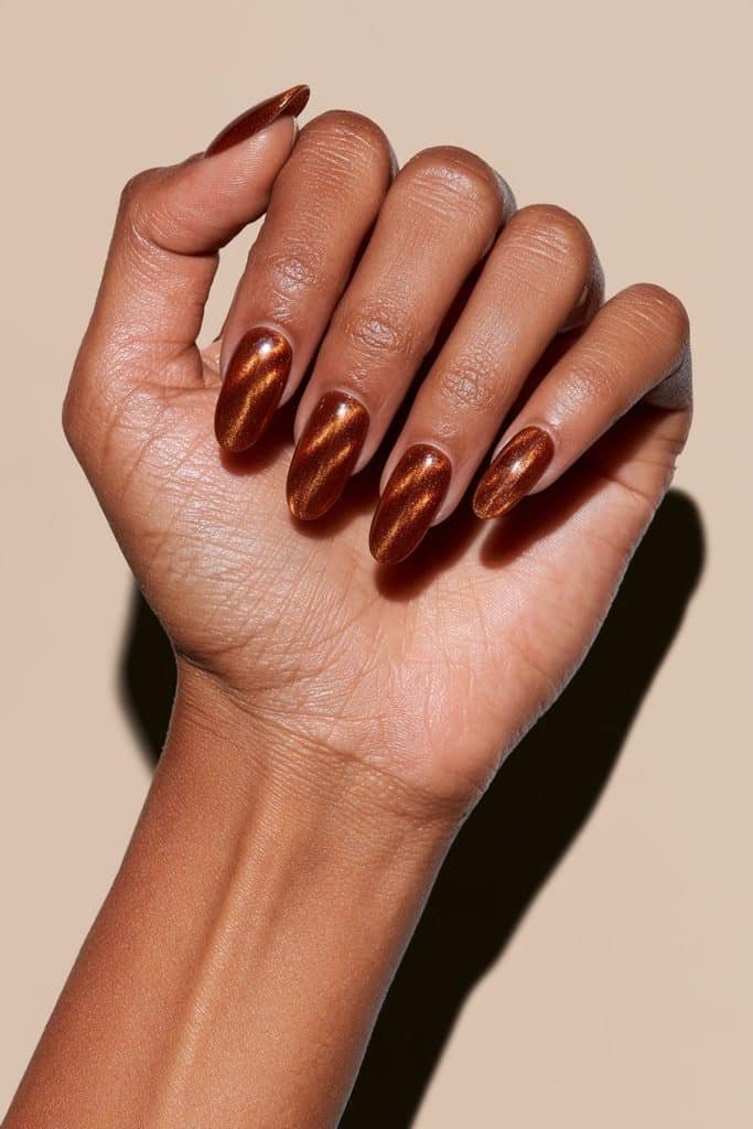 Amber orange cat eye nails with warm honey-gold reflections.