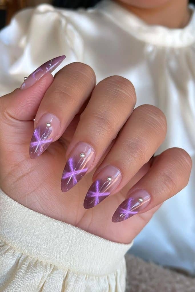 Amethyst cat-eye nails with radiant violet streaks and delicate silver pearl accents