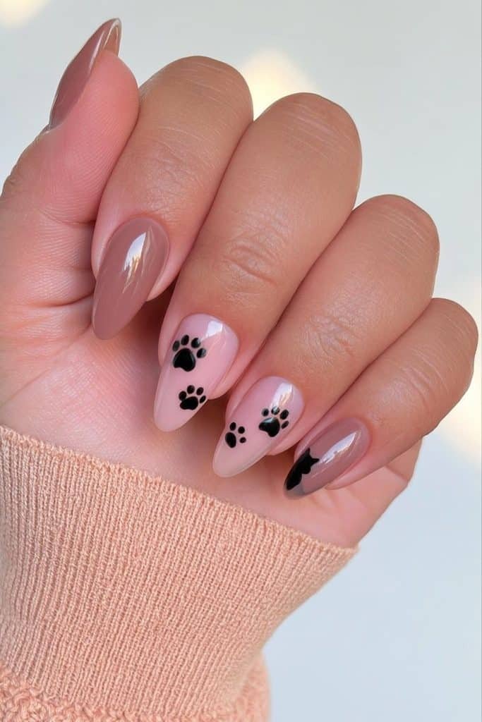 Sheer nude nails with tiny black cat paw prints and a delicate cat silhouette