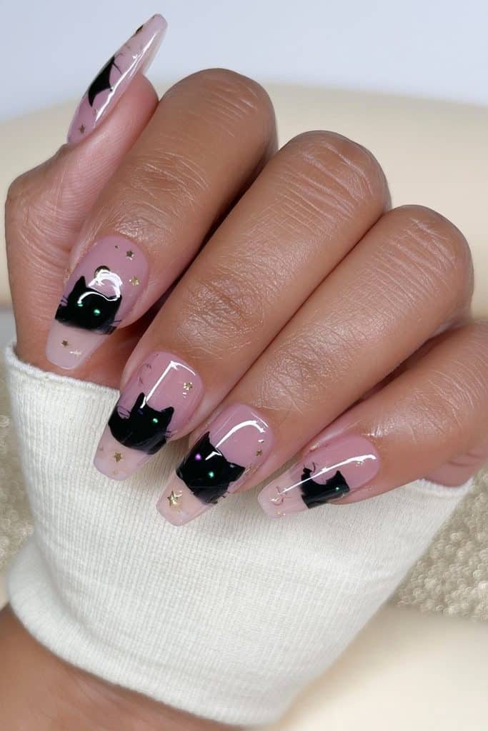 Black cat press-on nails with nude accents, tiny gold stars, and crescent moons
