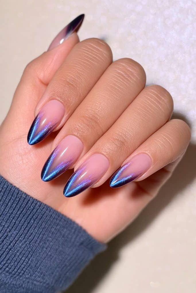 Blue-black cat-eye tip nails with near-black navy edges and vivid electric-blue streaks