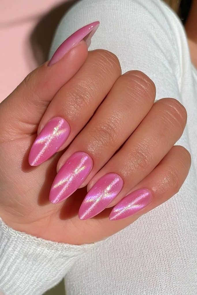 Bubblegum pink cat-eye nails with bright candy-pink highlights, rosy magnetic streaks, and glossy shimmer