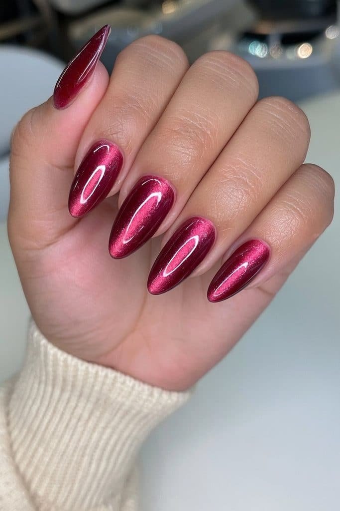 Merlot burgundy cat-eye nails with luminous ruby-wine glow and magnetic reflections