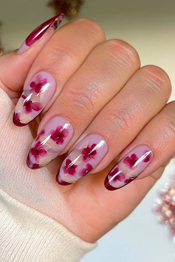 Burgundy floral nails with delicate wine-red blooms and soft creamy botanical accents