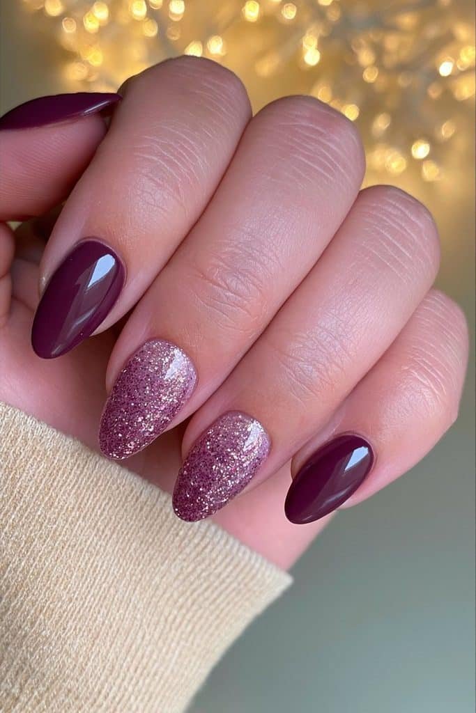 Glossy burgundy nails with elegant ruby and champagne glitter accent details