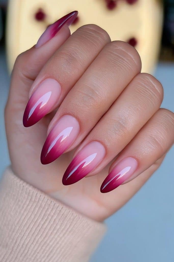 Burgundy ombré nails fading from a sheer nude base into deep wine-red tips