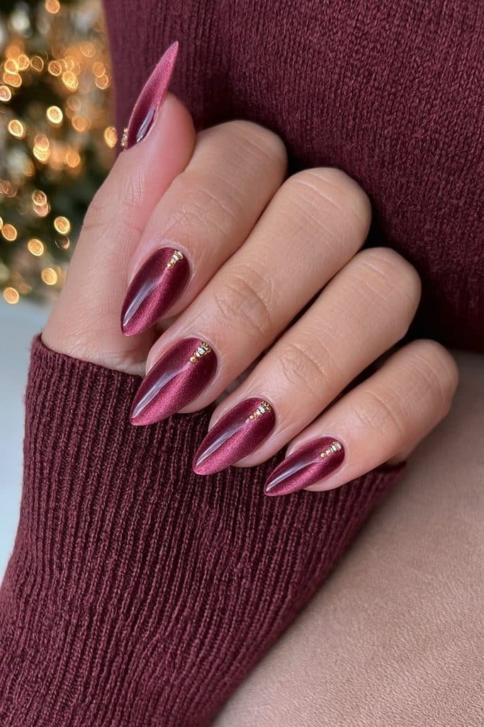 Burgundy velvet magnetic nails with nutcracker soldier accents and delicate gold braid