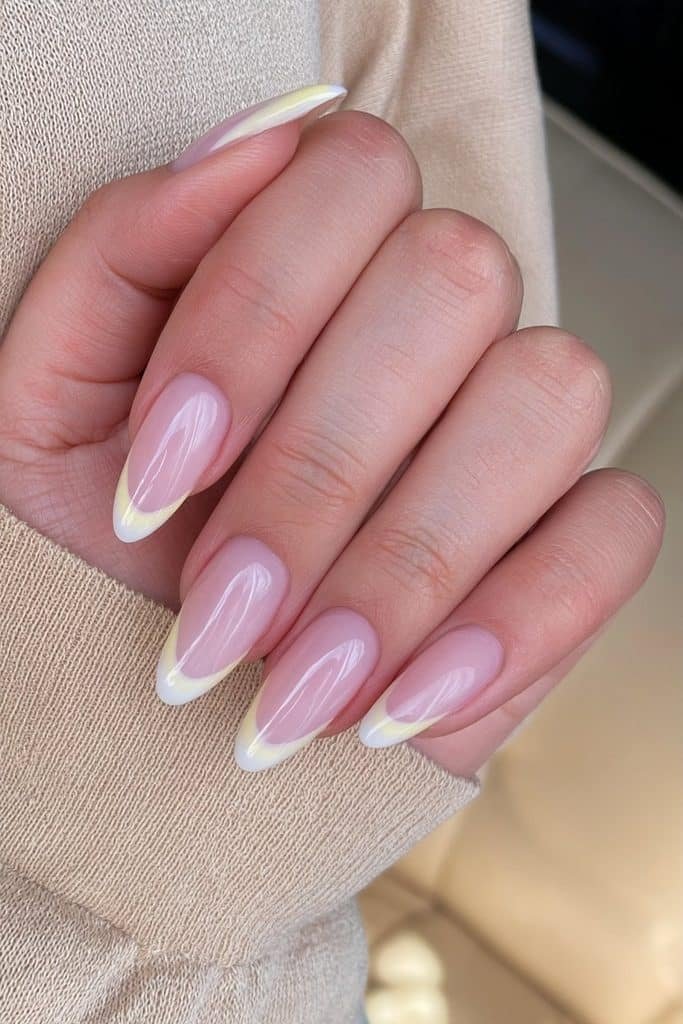 Butter yellow French tip nails with a sheer pink base and elegant curved yellow tips