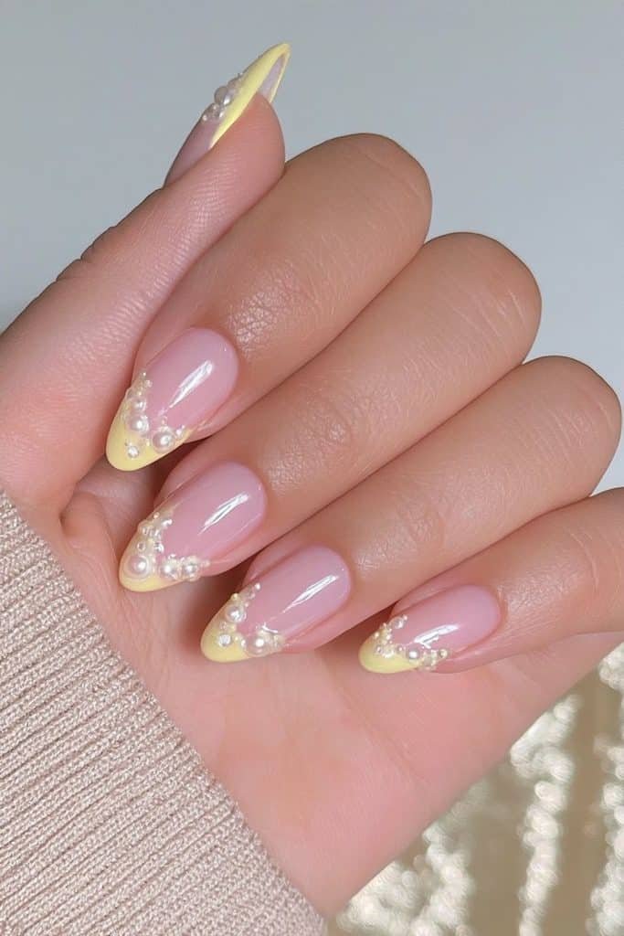 Butter yellow nails decorated with delicate raised ivory pearls and glossy pastel polish