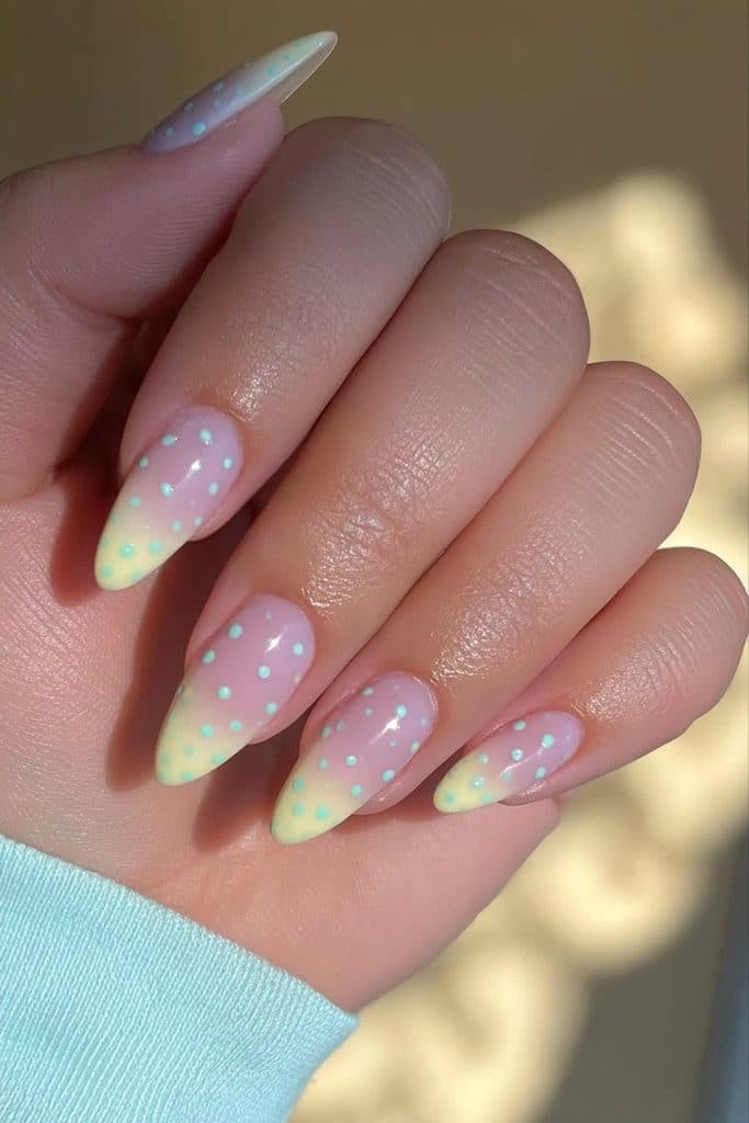 Butter yellow nails with tiny baby blue polka dots and a playful pastel design