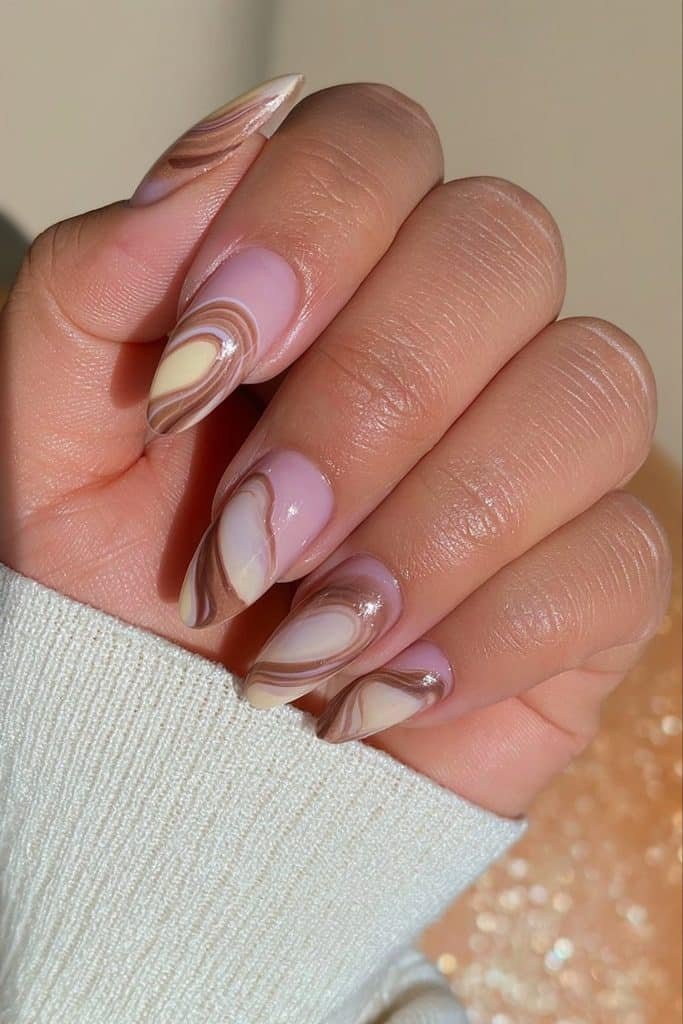 Butter yellow nails with flowing chocolate brown swirls and a glossy retro-inspired design