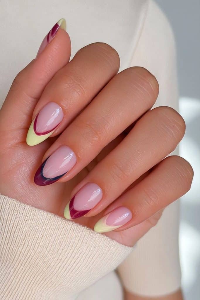 Butter yellow French tip nails with elegant navy blue and burgundy accent details