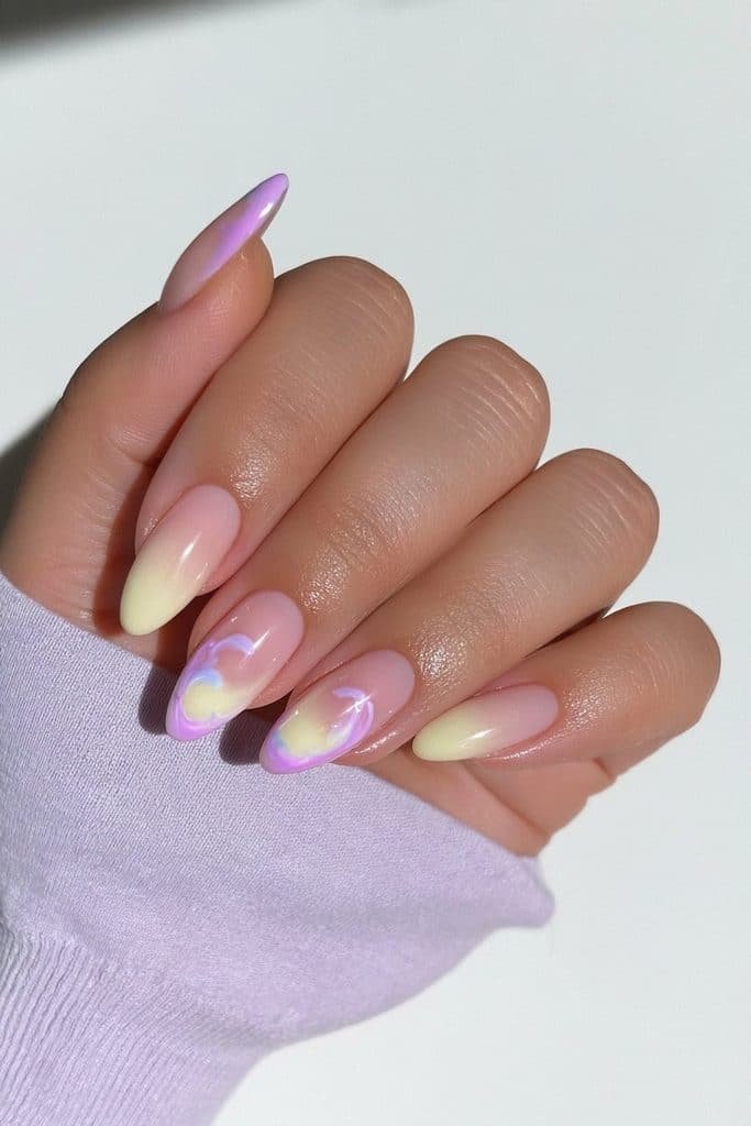 Butter yellow and lavender nails with pastel color blocking and delicate swirl accents