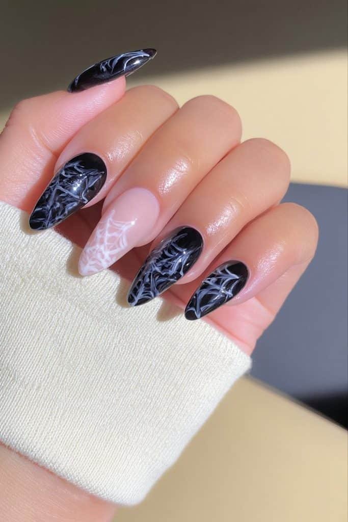 Black and white spider web nails with intricate web patterns and glossy monochrome polish