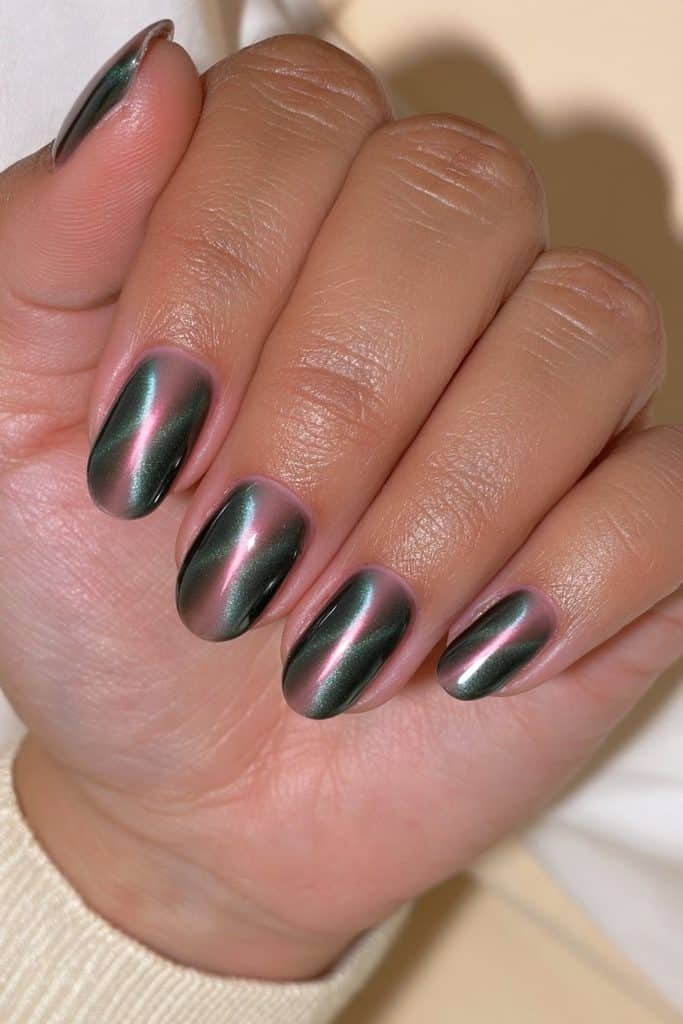 Short oval dark green cat eye nails with a centered emerald magnetic shimmer stripe and glossy finish
