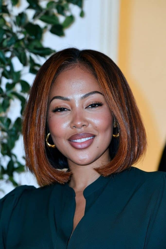 Black woman with a copper flipped bob haircut, featuring vibrant copper-colored hair, a smooth finish, and ends flipped outward for a bold, fashionable look.
