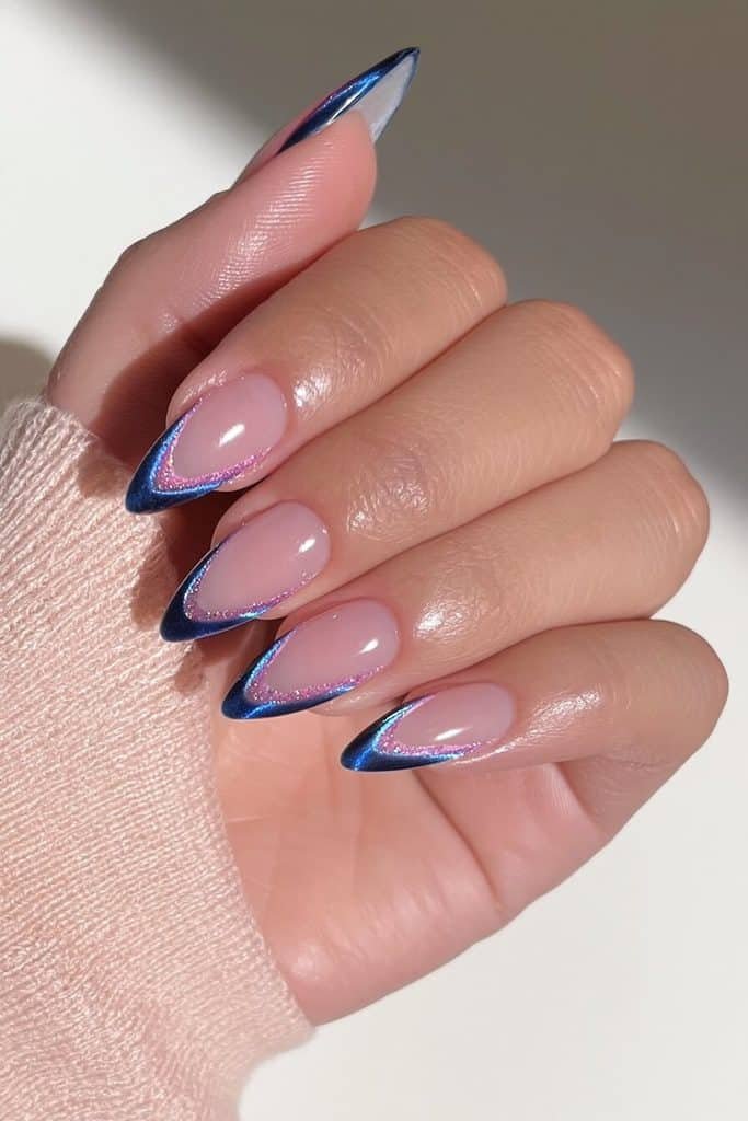 Dark blue cat-eye French tip nails with sheer pink bases and luminous sapphire tips
