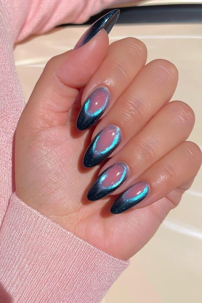 Dark blue cat-eye nails with luminous sapphire bands and a soft rosy-pink aura