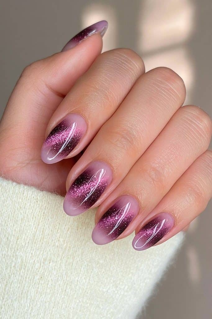 Dark purple cat-eye ombré nails fading from near-black plum to luminous royal violet