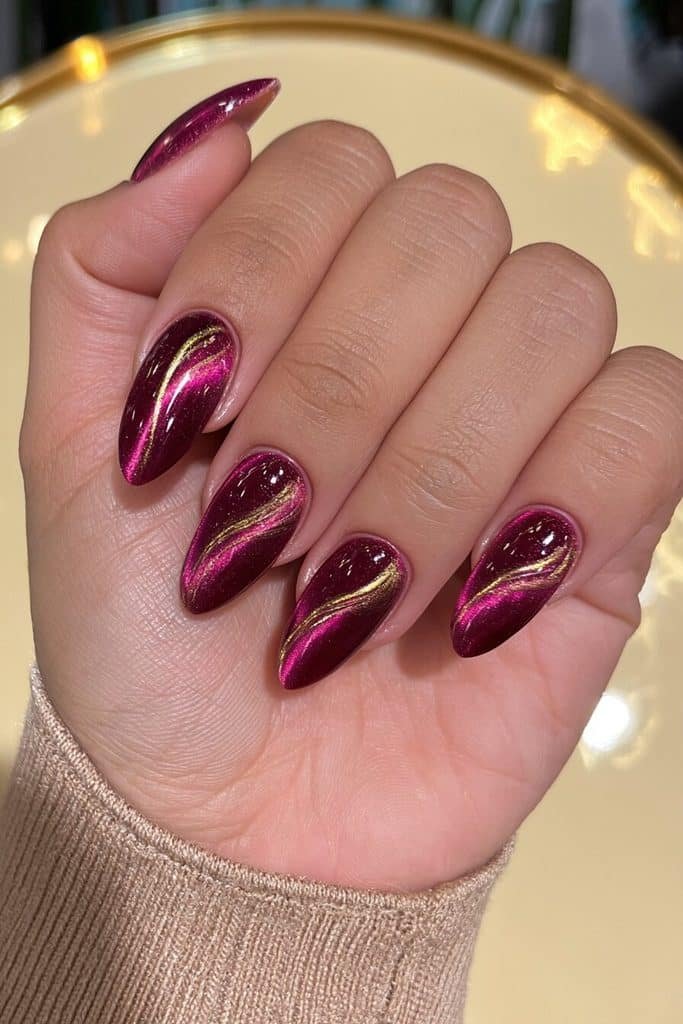 Dark purple cat-eye nails with molten gold swirls and luminous magnetic shimmer