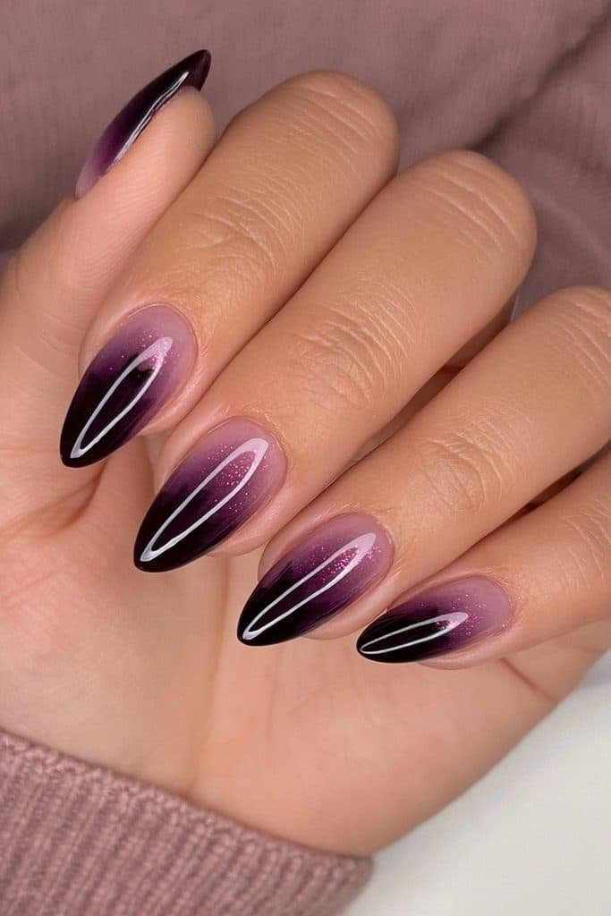Deep plum and blackberry nails with delicate black cat silhouettes and wine shimmer